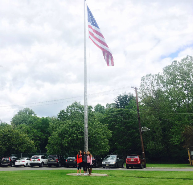 Juniors+Erin+Plunkett%2C+Abbie+Reissner+and+Michelle+Strathman+stand+at+the+base+of+the+American+flag+on+school+property.+The+girls+are+getting+ready+to+start+Memorial+Day+weekend.